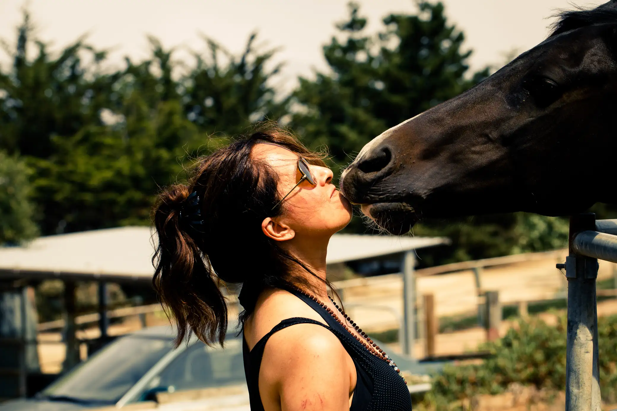 Beautiful woman playfully kissing a horse in Central Coast CA.