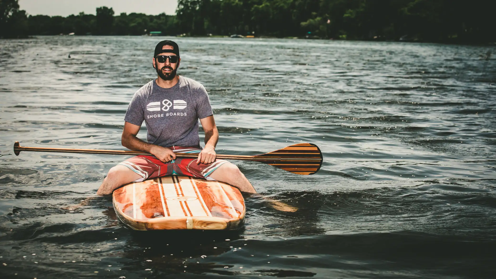 A young man aboard a paddle board in Minnesota.