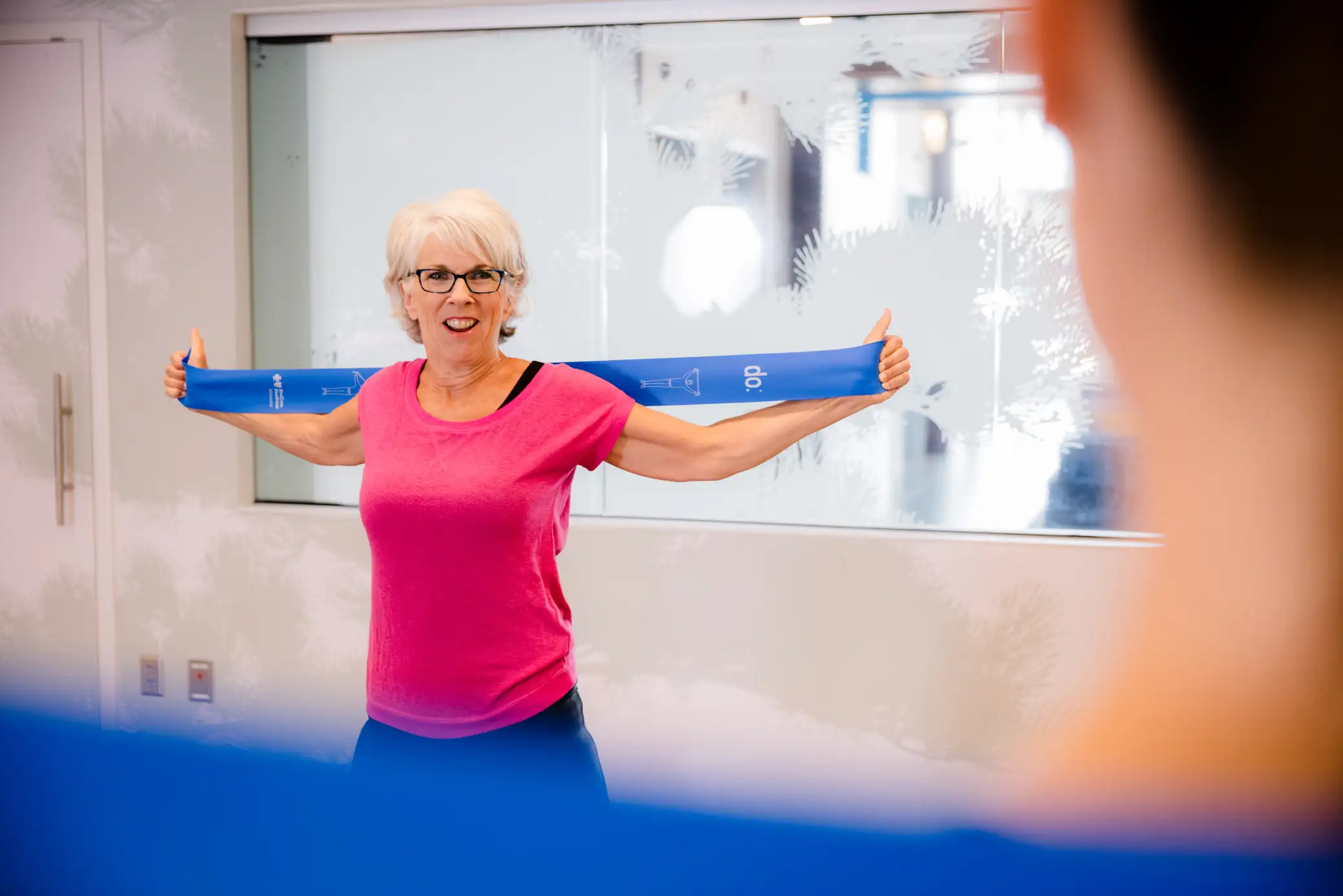 Photo of a 50+ woman stretching at an exercise class.